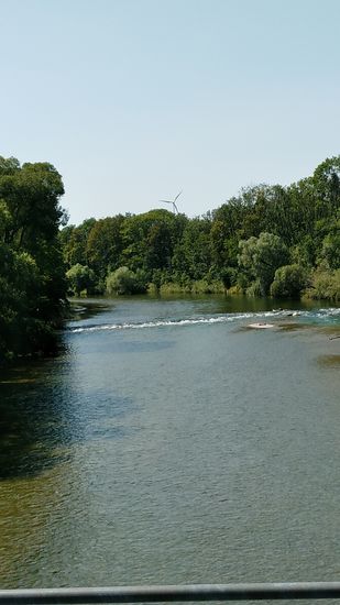 Im Blick zurück ist das mächtige Windrad auf der ehemaligen Müllbergdeponie erkennbar. 
In "Steinwurfweite" dieses Windrads befindet sich der "Hohe Tempel der Fußballkunst"   , sprich die Allianz-Arena. Allerdings vom Grüngürtel der Isar verdeckt.
Das Windrad ist in diesem Bericht die letzte Position, die noch auf Münchener Stadtgebiet zu sehen ist.