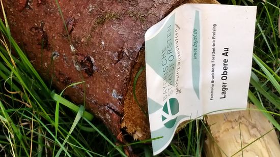 Ein Aufkleber zeigt den Standort, sowie den Eigentümer des mächtigen Holzlagers im unteren Bild.