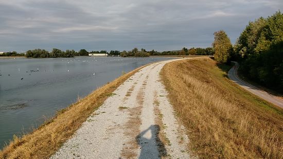 Mein Schatten hebt die linke Hand zum winkenden Gruße und weiter geht es auf der Dammkrone. 
Hat mich gewundert, daß auf dem unterhalb gelegenen Radweg mehrere Radler unterwegs waren, obwohl man dort ja keinen Ausblick geboten bekommt.