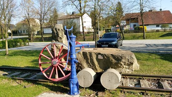 In Aufhausen passiert man einen originellen Steinbrunnen in angedeuteter Form einer Dampflokomotive. Das vorhandene Wasser in der Vertiefung unter dem Auslass der Handschwengelpumpe ist jedoch als "Kein Trinkwasser" ausgeschildert und somit leider nicht zum Durststillen für "ausgebrannte" Radler bzw. Wanderer geeignet.
Durch Aufhausen verlief die frühere Bahntrasse von Landau an der Isar nach Arnstorf, die heute den 48 km langen "Bockerlbahn-Radweg" darstellt, den ich  letztes Jahr schon während meiner Isar-Radtour gleich südlich von Landau/Isar bei der dortigen Stahl-Fachwerkbrücke kreuzte.