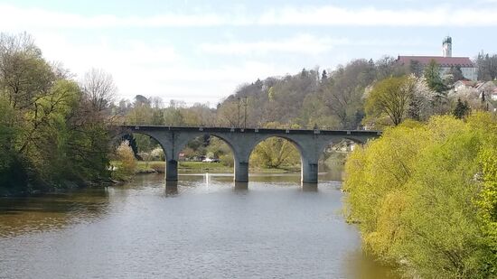 Der Blick zurück fällt auf die Eisenbahnbrücke der Hauptstrecke Passau (von links) nach Regensburg und weiter nach Nürnberg, sowie die Abteikirche Schweiklberg aus dem Jahre 1642 mit zwei 51 m hohen Türmen.
1804 wurde das damalige Kapuzinerkloster versteigert, 1904 dann von den Benediktinern von St. Ottilien (Nähe Ammersee) gekauft.