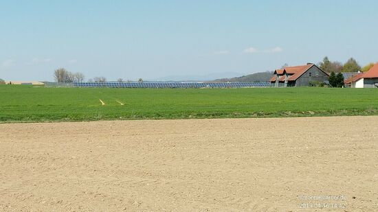 Inzwischen war Aldersbach wieder erreicht, auf das ich nicht mehr weiter eingehen möchte und verließ dort endgültig das Tour-Hauptthema "Vils" incl. ihres angeschlossenen Radwegs.
Von dort ab war dann ein kurzes Stück Bahntrassen-Radeln auf einer ehemaligen Nebenstrecke (auch (untere) Vilstalbahn genannt) angesagt, die auf einer Länge von 12,5 km von Vilshofen bis Aidenbach führte.
Diese Nebenbahn wurde zum Jahresende 1987 geschlossen und die Trasse in den frühen 1990er-Jahren abgebaut. Gegenwärtig verläuft auf der ehemaligen Trasse der von mir gerade benutzte Radweg.
Ab Aidenbach fährt man dann sowohl auf der normalen Straße, auf diese begleitenden Radwegen und wo der Radweg auch mal sein vorübergehendes Ende fand, verlief meine Spur auch mal etwas abgesetzt auf beschilderten Feldwegen zwischen Wiesen und Äckern hindurch.
Auf diesem Bild sieht man rückblickend in Bildmitte ganz in der Ferne nochmals schemenhaft Ausläufer der Höhenzüge des Bayerischen Waldes.