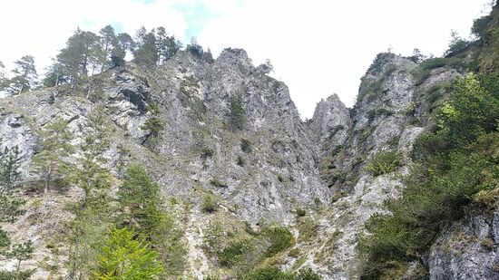 Imposante und schroffe Felswände begleiten das alte Straßenstück.