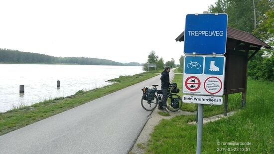 Als Treppelweg oder auch Leinpfad wird ein Weg unmittelbar am Ufer von Flüssen oder Kanälen bezeichnet, der angelegt wurde, damit Menschen und Zugtiere Frachtschiffe flussaufwärts ziehen konnten. Den Vorgang nannte man treideln. 
Über ein Tauwerk waren die auf den Leinpfaden gehenden Treidler und Treidelpferde mit den Schiffen verbunden. 
Die Treidelschifffahrt ging mit dem Aufkommen von maschinengetriebenen Schiffen und Schleppern zu Ende. Bis in die 1980er Jahre war das Betreten der ehemaligen Leinpfade nur auf eigene Gefahr gestattet. Sie unterliegen bis heute der Verwaltung der Wasser- und Schifffahrtsämter (WSA). 
Aus den meisten der Leinpfade sind mittlerweile Uferpromenaden, Rad- und Wanderwege oder Betriebswege der Wasser- und Schifffahrtsverwaltung geworden.
Entlang der Donau ist der Treppelweg über weite Strecken von Bayern bis nach Rumänien an beiden Ufern erhalten und als Donauradweg bis Budapest ausgebaut.
Übrigens:
Den Namen des Radlers an der Infotafel hab ich mir nicht notiert und inzwischen auch vergessen. Er stammt aus Tschechien und war per Rad unterwegs zum Dienstantritt bei seinem neuen Arbeitgeber im Gastronomiesektor in der Schweiz !
Da die Unterhaltung in unseren jeweiligen Landessprachen äußerst dürftig war, er kannte immerhin einige deutsche Wörter (tschechisch bei mir Fehlanzeige), konnte ich ihn zu seinem Vorteil auf englisch darauf hinweisen, nicht in Richtung Passau weiterzufahren, sondern über das bald folgende Kraftwerk auf die südliche Donauseite zu wechseln und von dort die weitere Großrichtung über Wels, Salzburg etc. zu wählen, um viel unnötigen Umweg zu vermeiden.
