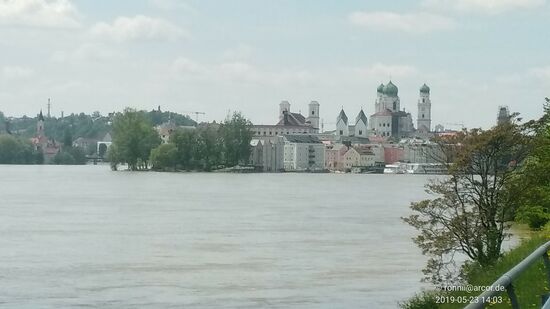 Hinter der Baumgruppe in Verlängerung der Altstadt fließt der Inn seinem Ende entgegen und mündet in die Donau. Der eigentlich begeh- bzw. beradelbare Mündungsspitz links der Baumgruppe steht wegen des bestehenden Hochwassers leider unter Wasser und der Zugang zu dieser Ortsspitze war, wie etwas später auch ersichtlich, gesperrt.