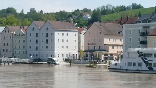 In der Altstadt kühlt ein Lieferwagen seine Vorderreifen im Donau-Hochwasser.