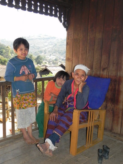 Die Oma passt auf die Kinder auf während die anderen Familienmitglieder Tee für den Verkauf nach Mandalay vorbereiten.