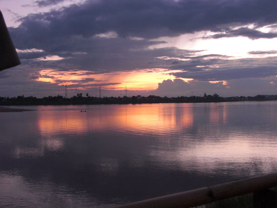 Sonnenuntergang am Mekong. Schoener Blick von einem improvisierten Terrassenrestaurant am Nachtmarkt.