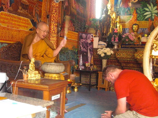 Marcus laesst sich von einem der Moenche segnen und im Anschluss ein Armbaendche fuer mehr Glueck geben.