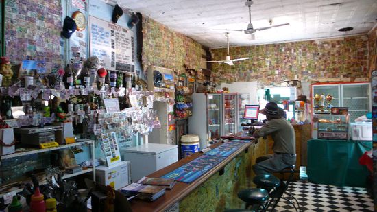 förmiges Pub an der Tankstelle mit räuschigen Leuten zmitzt in der Wüste inen