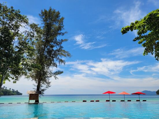 Aussicht vom Liegestuhl aus: Pool und dahinter das Meer