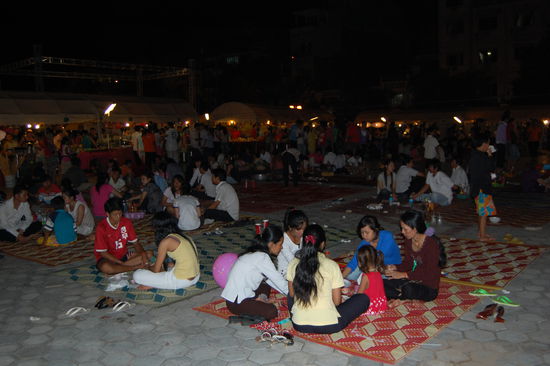 Abends auf dem Nachtmarkt sitzen die Einheimischen auf Matten beim Abendessen.