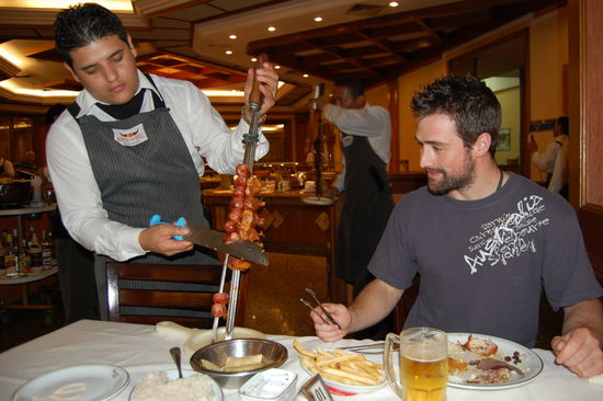 Hier ein Kellner, der Stefan Fleisch abschneidet.