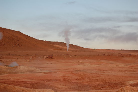Der Geysir blaesst auch bei Tageslicht immer noch seinen Dampf in die Luft.
