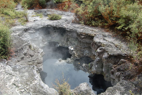 Aufgebrochene Erdkruste aus der Dampf steigt.