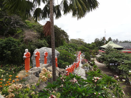 Mönche bringen dem goldenen Buddah Opfergaben