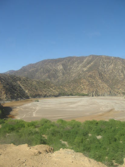 Am fast ausgetrockneten Flusslauf ist noch etwas Gruen