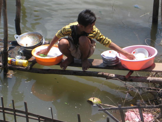 Junge beim Geschirr spülen