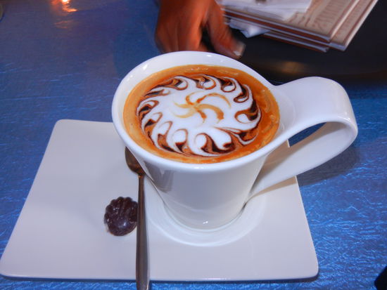 leckeren Kuchen mit kleinen Kaffee-Kunstwerken
