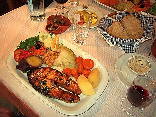 Bom apetite! Lachs, frisches Gemüse und Brot, Oliven und Rotwein