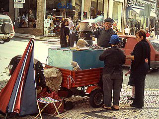 Sie sind aus dem Straßenbild Portugals nicht wegzudenken, die Esskastanienverkäufer und –verkäuferinnen. Und ich kann an ihnen nicht vorbei.