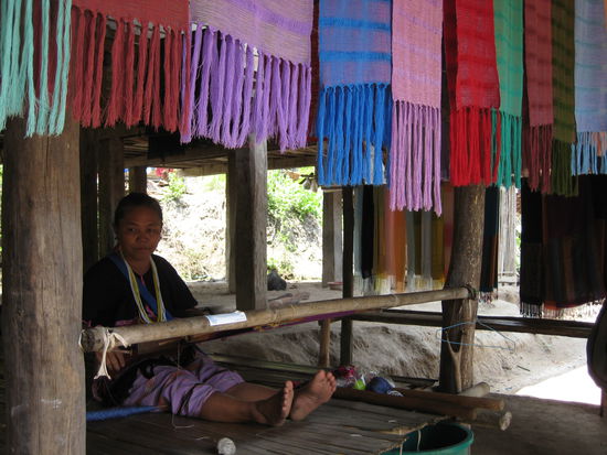 Watch refugees from Burma, who live in Thailand, weaving beautiful scarfs.