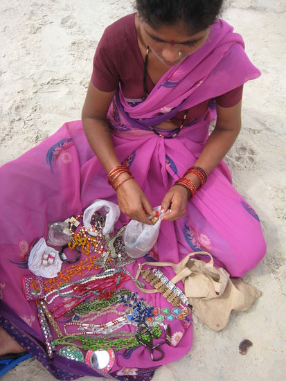 Selling trinkets to earn at least enough to feed her kids and maybe herself, this mum is great, because she is not sending her playing kids to me to beg for money, but trying to do her best to improve the family situation.