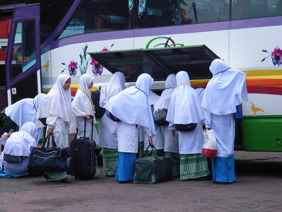 Die Mitreisenden verstauen ihr Gepäck.