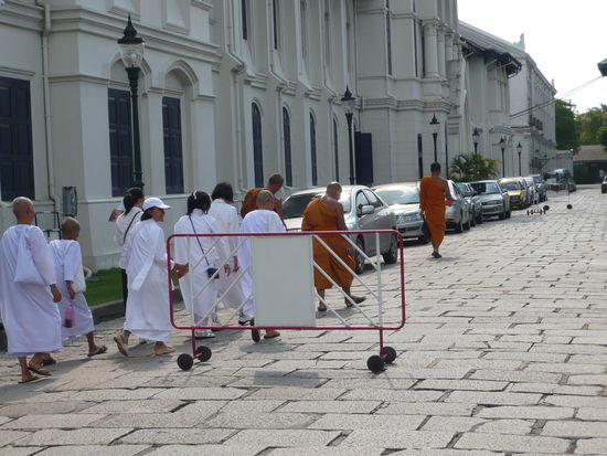 Ueberall sieht man hier die buddhistischen Moenche in ihren einfachen orange-farbenen Gewaendern.
Diese haben sich fuer ein Leben mit sehr wenig Besitztuemern und staendigem Beten entschlossen. 
Sie besitzen lediglich ihre Kleidung und eine Almosenschale. Mit dieser gehen sie dann wortlos taeglich durch die Strasse und erhalten so ihr Essen von Spendern.
