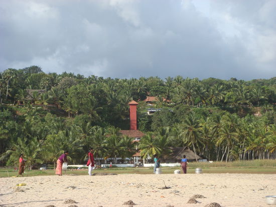 Mitten in den Palmen ist unser Hotel zu erahnen (die Frauen auf dem Foto haben am Strand tote Fische ausgelegt um sie zu trocknen, dem Grund gehen wir noch nach...)
