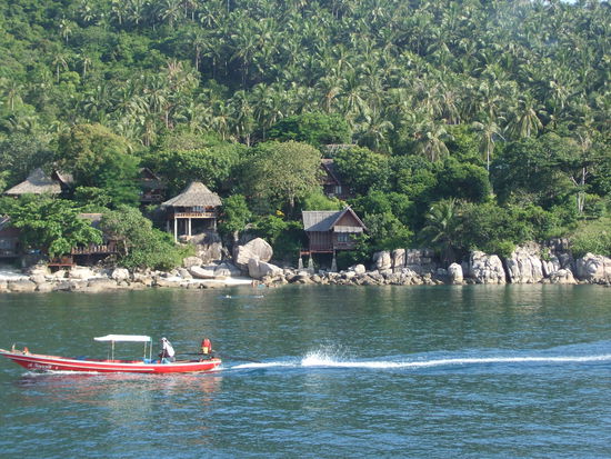 Ein Bild vom typischen Koh Tao-Feeling... Longtailboote und Bambushuetten auf felsigem Grund direkt am Wasser...