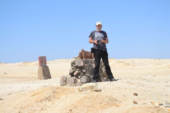 ein mann und seine kamera kämpfen gegen jedes aufgewirbelte sandkorn