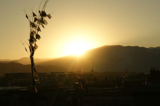 Sonnenuntergang mit Blick auf die Daecher von Lhasa.