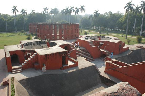 Jantar Mantar - eine Sternwarte eines Maharadschas im Jahre 1725 erbaut. Spezielle Bauten umgeben von Palmen und modernen Hochhaeusern.