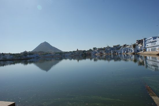 Der See in fast seiner vollen Groesse. Im Hintergrund auf der Spitze des Huegels sind die Umrisse des Savitri-Tempels zu sehen.