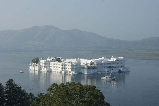 Aussicht von der Dachterrasse von unserem verschmaehten, aber reservierten Hotel. Blick auf die Jagniwas-Insel mit dem grossen Luxushotel Lake Palace Hotel.