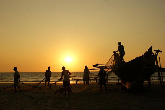 Getrocknete Fischernetze werden auf das Boot gelegt, bereit fuer den naechsten Morgen