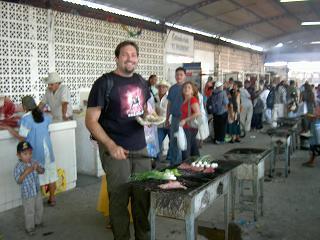 Leider etwas unscharf: Niels auf dem Markt beim Braten von Fleisch und Gemuese, die obligatorischen (Riesen-)Tortillas fehlen natuerlich auch nicht.