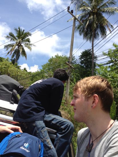 Jetzt sind wir mit 10 Personen und Gepäck auf dem Weg. Die obersten Rucksäcke sind gesichert durch den Typen im blauen Shirt. Wenn der Rucksack beim Bremsen das Auto verlässt, dann