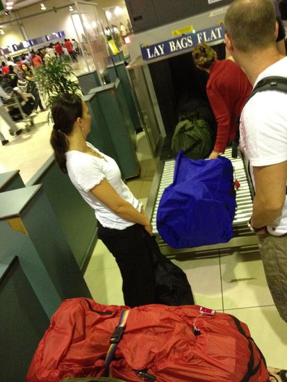 Safety first. Zur Sicherheit müssen die Rucksäcke gescannt werden, bevor wir an den Schalter dürfen. Komisch ist nur, daß die Kontrolleure öffters nicht auf ihre Bildschirme schauen, sondern es wichtiger finden, meinen Reissverschluß mit Aufkleber "zuzubäbsen" (zuzukleben).