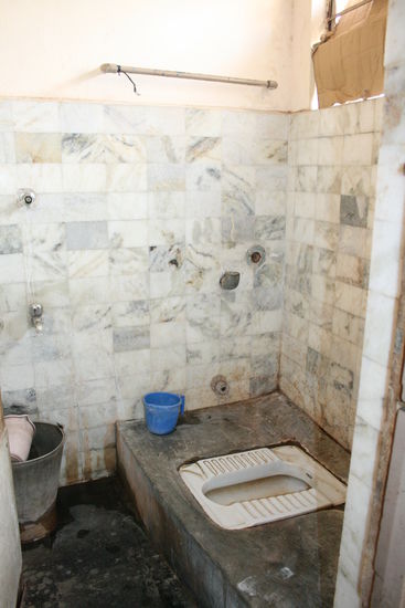 Und fuer die, die es noch genauer wissen wollen: Das Bad! Links (der Metalleimer) ist die Dusche und rechts (das weisse) die Toilette. Der kleine blaue Eimer ist die Spuelung der Toilette.