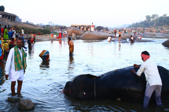 Lakshmi und Inder beim baden im Fluss
