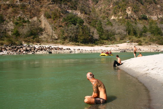 Ganges, Rafting Boot un Akisch der auf einem Stein im Wasser sitzt!