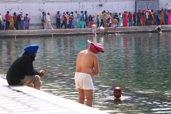 Einmal rein-waschen im heiligen Wasser um den Tempel. 
Hier kann man den Dolch des Sikhs (am Turban) ganz gut sehen. Neben dem silbernen Armreif und dem Turban, tragen die Sikhs auch staendig einen Dolch am Koerper