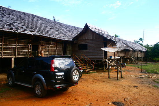 Das Longhouse von aussen mit unserem Auto davor (Hier gibt es eigentlich nur Motorraeder)