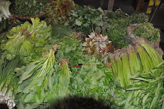 Gemüse und Gräser auf dem Markt in Pakse ...