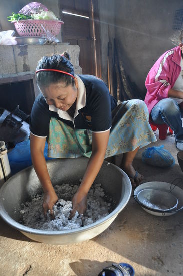 Kokosnussfleisch wird mit heißem Wasser übergossen, darin gespült und ausgedrückt. Die Brühe wird später zum Kochen eines Nachtisches (Reis mit Banane im Bananblatt) verwand. Super lecker!