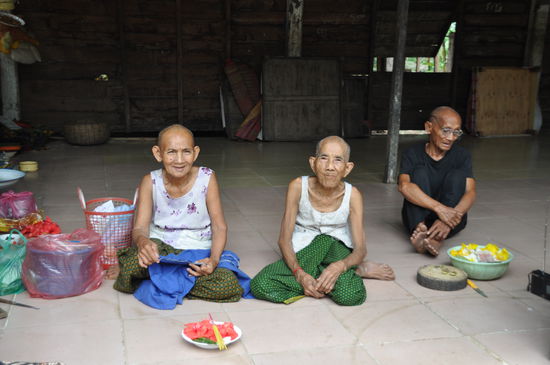 Als wir  in der Pagoda weiter gingen, kamen wir zu einem Haus, das nur eine Rückwand hatte. Drei alte Leutchen saßen auf dem Boden. mein Guide erzählte mir, dass die Pagoda Kinder und alte Menschen die keine Familie mehr haben aufnehmen. Diese drei alten Leutchen warten hier auf ihr weggehen in eine andere Welt. Sie sahen aus wie  Menschen bei uns, die über hundert Jahre alt sind. Aber Phallin fragte wie alt sie sind und sie sagten sie wären so um die 74-75 Jahre. Als wir uns den alten leuten näherten, sagte die linke Frau "ich kann sie nicht sehen, meine Augen sind so schlecht" (Phallin übersetzte mir). Ich ging näher, zeigte ihr meine Brille und setzte sie mir auf die Nase. Daraufhin grinste die Alte Frau, fing an im Korb zu kramen und holte eine Brille mit riesigen Gläsern heraus und setzte sie sich ebenfalls auf die Nase. Allerdings so schnell wie sie die Brille an hatte, war sie auch schon wieder im Korb verschwunden. Und meinte: "Brillen auf der Nase machen häßlich". Der Opi im Hintergrund schaute sie gequält an und sie grinste über das ganze Gesicht. Wir plauderten noch eine Weile und dann gingen wir unseres Weges weiter in der Pagoda.
