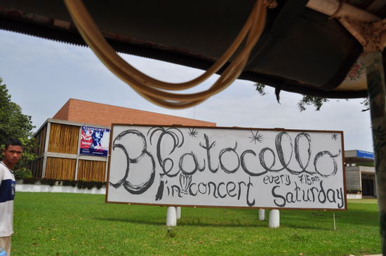 Konzertplakat und dahinter die Halle in der die Konzerte stattfinden.