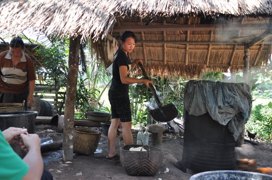 Von der Feuerstelle wird der Reis in einen Korb gefüllt und